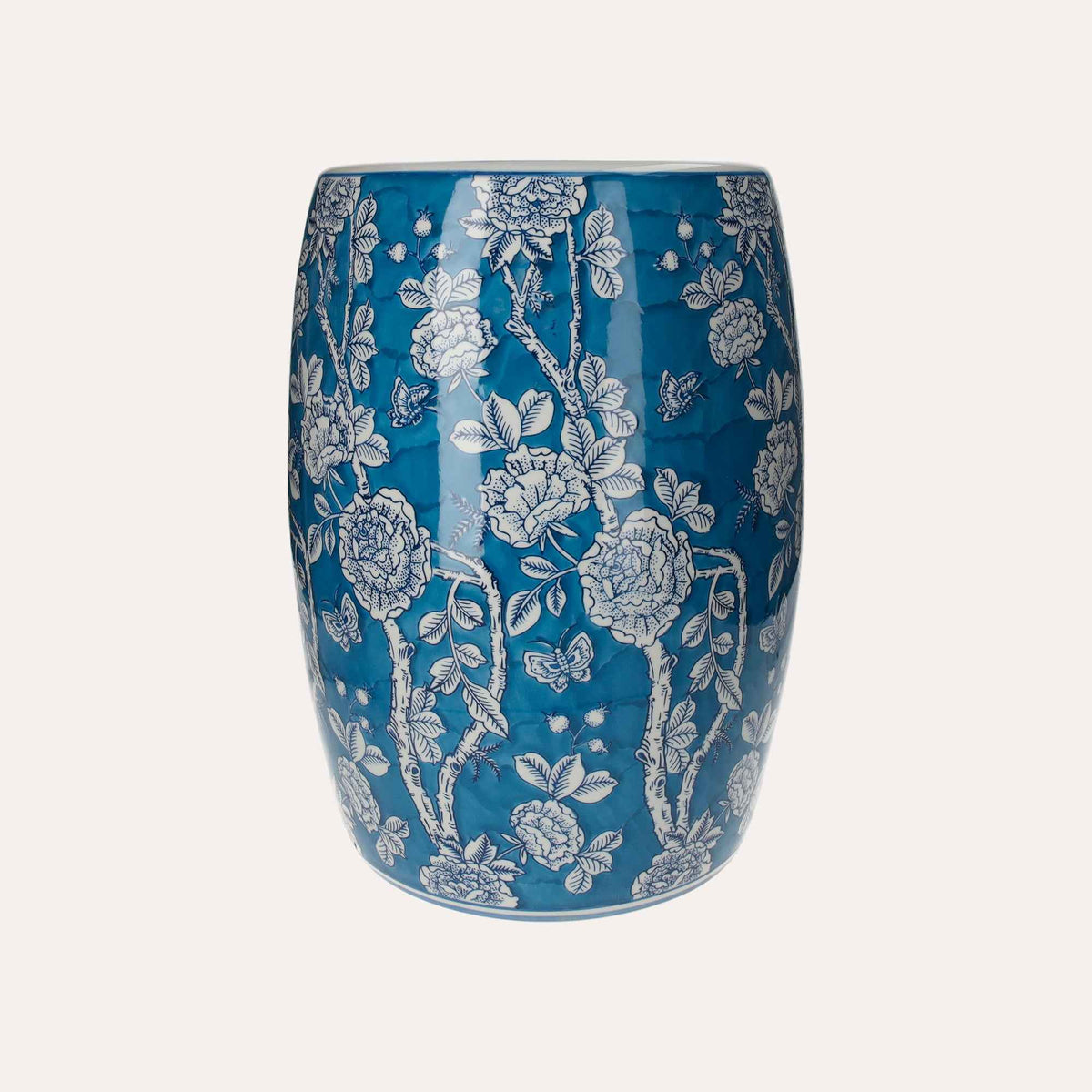 Puf de porcelana decorado con flores blancas y mariposas.