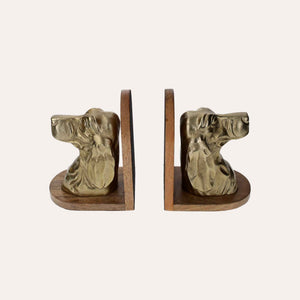 Sujetalibros con forma de busto de perro de metal dorado sobre soporte de madera