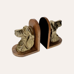 Sujetalibros con forma de busto de perro de metal dorado sobre soporte de madera